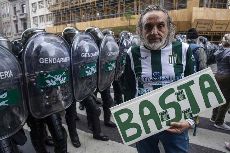 Okruženi policijom, prosvjednici su skandirali: &apos;Ne dirajte starije&apos;. Muškarac ogrnut argentinskom zastavom držao je natpis na kojem je pisalo &apos;Pomozi mi u borbi. Ti ćeš biti sljedeća starija osoba&apos;