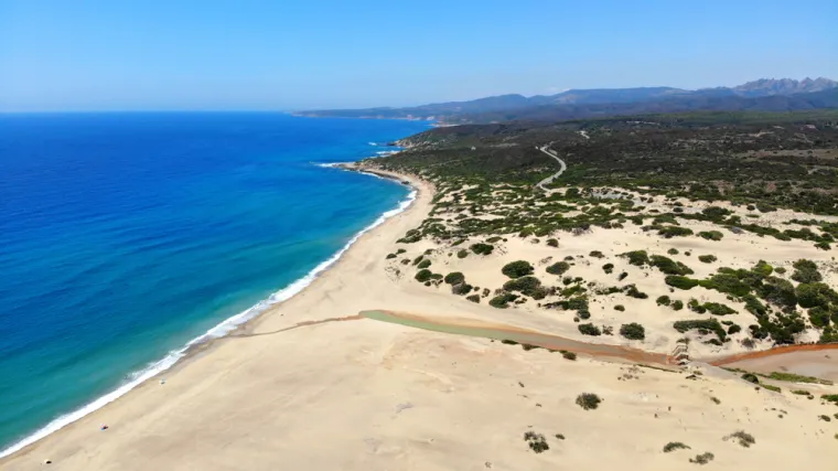 11. Piscinas Beach, Sardinija, Italija (54/100): Plaža je smještena na zapadnoj obali Sardinije, u području Costa Verde. Poznata je po velikim površinama zlatnog pijeska i kristalno čistoj vodi, što je čini jednom od najljepših plaža u regiji. Okružena visokim pješčanim dinama, koje dosežu visinu do 50 metara, i brdovitim krajolicima, Piscinas nudi dramatičan i netaknut pejzaž. Zbog svoje udaljene lokacije, plaža pruža mirnu atmosferu, idealnu za one koji žele pobjeći od gužve i uživati u prirodnoj ljepoti ovog područja. Plaža je popularna među ljubiteljima jedrenja na dasci i kitesurfinga. 