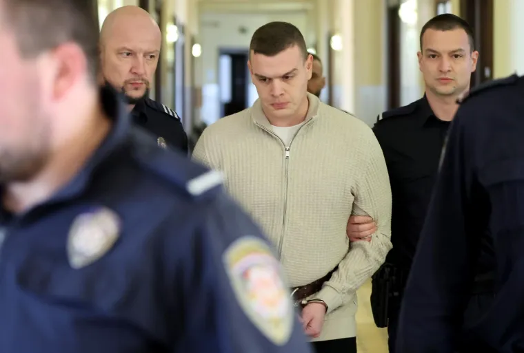 
Optužnica tereti policajca Marka Smažila da je je 20. rujna 2023. oko 22 sata, u svom stanu u Osijeku, u nakani da usmrti 21-godišnju žrtvu, s kojom je bio u vezi, iz službenog pištolja marke &quot;HS-9&quot; ispalio hitac u glavu Mihaele Berak