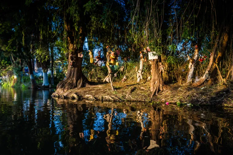 LA ISLA DE LAS MUÑECAS - Otok lutaka, smješten u kanalima Xochimilca južno od Mexico Cityja, jezivo je mjesto prekriveno stotinama raspadajućih lutaka. Ova mračna atrakcija nastala je kada je Don Julián Santana Barrera, samotnjak koji je živio na otoku, počeo vješati lutke po drveću nakon što je navodno pronašao utopljenu djevojčicu u obližnjem kanalu. Vjerovao je da lutke umiruju duh djevojčice i štite ga od zla, Julián je desetljećima sakupljao i postavljao lutke, čime je stvorio sablasnu atmosferu koja privlači znatiželjnike iz cijelog svijeta. Posjetitelji često prijavljuju da lutke pomiču glave i ruke, otvaraju oči, pa čak i šapću među sobom, dodajući novu dimenziju jezi ovog jedinstvenog i ukletog mjesta.