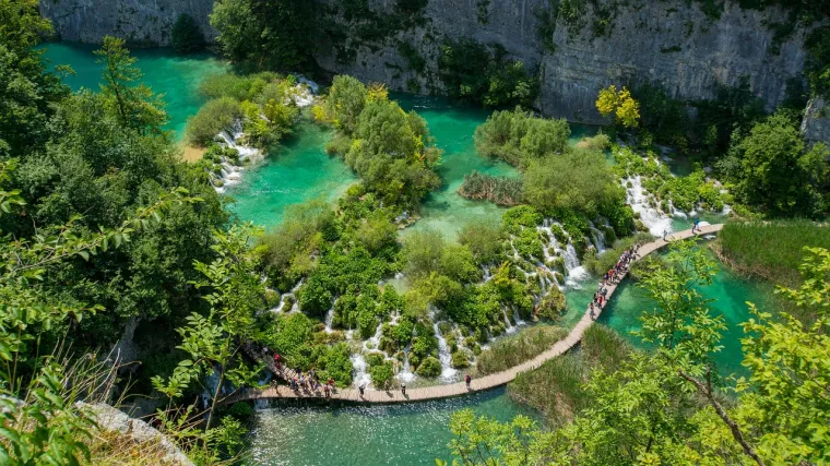 1. Nacionalni park Plitvička jezera: Apsolutni klasik i svjetski poznati biser prirode. Šesnaest tirkiznih jezera povezanih spektakularnim slapovima, okruženih gustim šumama, prizor je koji oduzima dah u svako doba godine, a proljeće im daje posebnu čar. Prošećite drvenim stazama, provozajte se električnim brodićem ili vlakićem i dopustite da vas očara ova jedinstvena ljepota upisana na UNESCO-ov popis svjetske baštine. Idealno za ljubitelje prirode i fotografije.