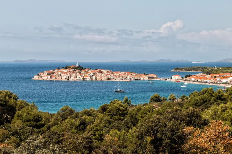7. Primošten: Slikoviti gradić na poluotoku, čija je panorama s crkvom sv. Jurja na vrhu jedan od najprepoznatljivijih motiva Dalmacije. Primošten je poznat po prekrasnim plažama i čuvenim vinogradima sorte Babić, čije kamene međe tvore jedinstven krajolik. Idealno mjesto za miran odmor i uživanje u mediteranskom ambijentu.
