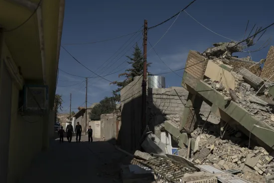 People walk next to a destroyed house after an earthquake at the city of Darbandikhan, northern Iraq, Monday, Nov. 13, 2017. A powerful 7.3 magnitude earthquake near the Iraq-Iran border has killed over 350 people across both countries, sent residents fleeing their homes into the night and was felt as far away as the Mediterranean coast. (AP Photo/Felipe Dana)