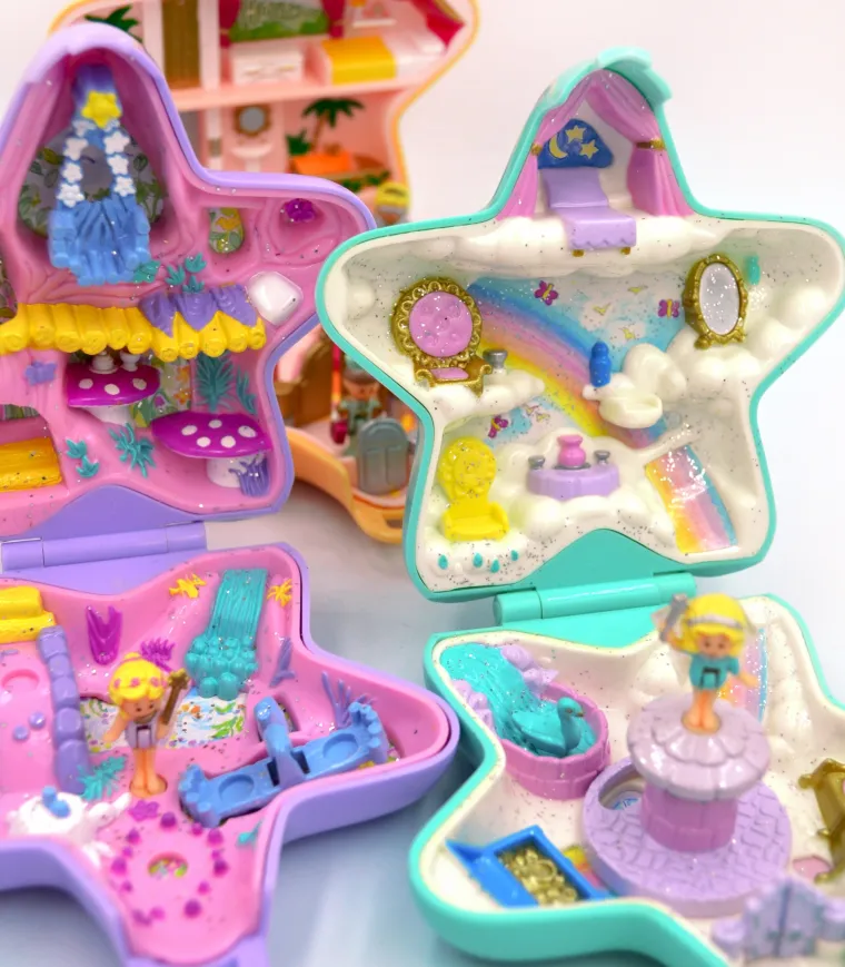 POLLY POCKET -  bila je prava senzacija među djevojčicama 90-ih i savršen božićni poklon koji je dolazio u malenom, šarenom pakiranju. Ovi sićušni svjetovi, smješteni u kompaktnim kutijicama u obliku školjki, srca ili zvijezda, nudili su beskrajne mogućnosti za igru i maštanje. Svaka kutijica skrivala je čarobne minijaturne svjetove – kuće, parkove, dvorce ili čak podvodne avanture – a dolazila je s malenim figuricama Polly i njenih prijatelja.