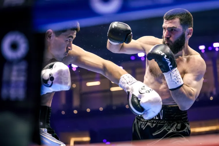 Dmitrij Bivol i Artur Beterbiev. Bivol baca udarac, Beterbiev se brani. 