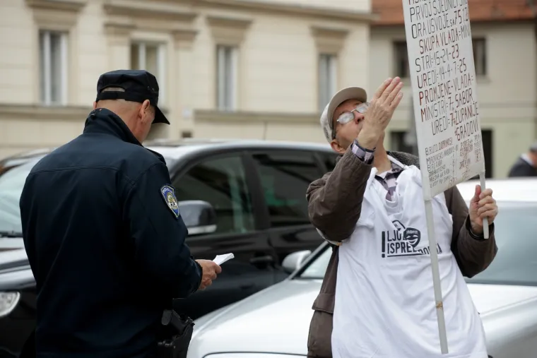 Policajac provjerava identitet prosvjednika na markovom trgu