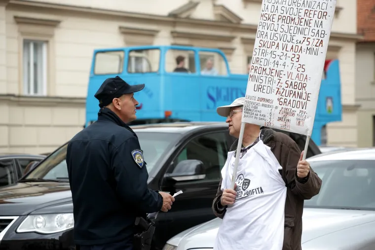 Policajac provjerava identitet prosvjednika na markovom trgu