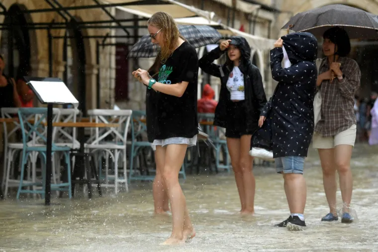 Stradun je pod vodom, no to nije omelo turiste: Dobro se zabavljaju i trče bosi