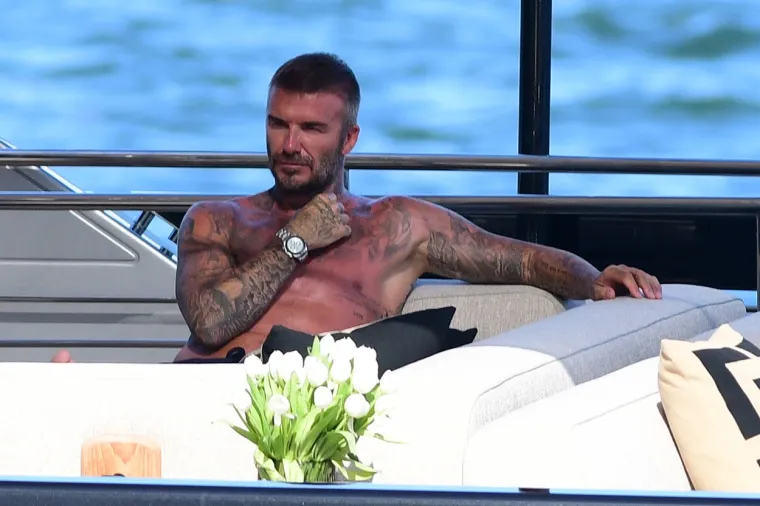 David Beckham pokazao svoj preplanuli torzo na jahti: Dok ga je usluživala zgodna žena nije skidao osmijeh s lica