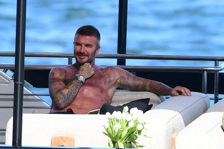 David Beckham pokazao svoj preplanuli torzo na jahti: Dok ga je usluživala zgodna žena nije skidao osmijeh s lica