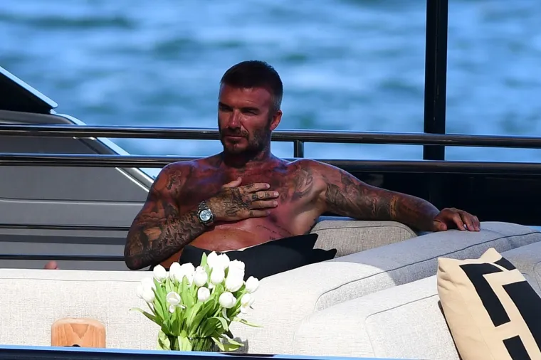 David Beckham pokazao svoj preplanuli torzo na jahti: Dok ga je usluživala zgodna žena nije skidao osmijeh s lica