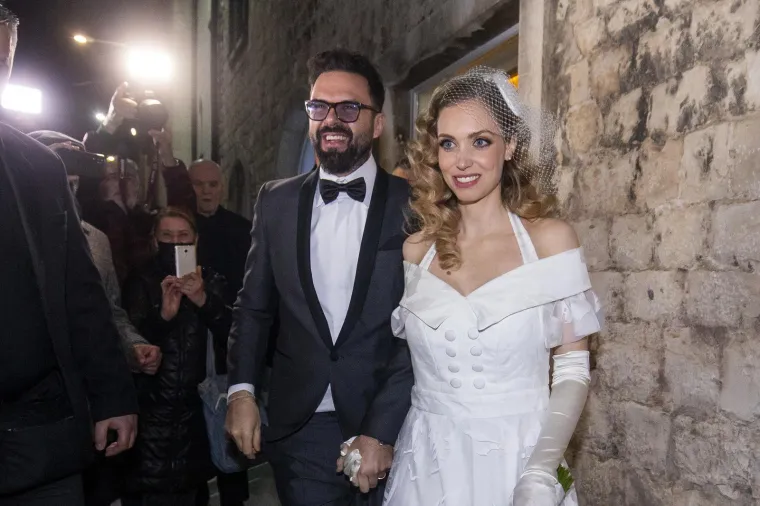 Mlada je nosila vjenčanicu splitskog modnog brenda Arileo, koja je izrađena u vintage stilu sa srcolikim blagim izrezom s prednje strane i lepršavog donjeg dijela.