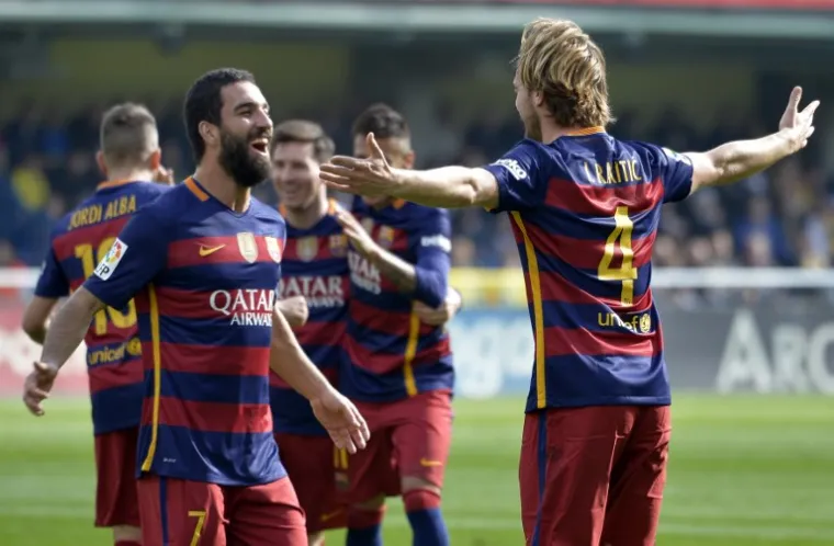 Barcelona's Croatian midfielder Ivan Rakitic celebrates a goal with Barcelona's forward Arda during the Spanish league football match Villarreal CF vs FC Barcelona at El Madrigal stadium in Vila-real on March 20, 2016. (Photo by JOSE JORDAN / AFP)