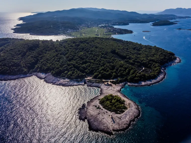 Rt Ražnjić najistočnija je točka Korčule i skriveni dragulj otoka. Na jugoistočnom dijelu otoka Korčule, kraj Lumbarde, krije se Rt Ražnjić. Lumbarda je drugo najstarije obalno mjesto na otoku, a priče kažu da je njen Rt Ražnjić prvo što su Grci ugledali po dolasku na otok.

Poluotok Ražnjić ujedno je i najistočniji dio otoka. Ima zanimljivu povijest - nekad su tu bile vojarne čiji derutni objekti godinama čekaju obnovu. Također, poznat je po svojoj predivnoj prirodi. Autohtona dalmatinska sorta alepskog bora dominira ovim područjem, stvarajući šumu koja privlači šetače i istraživače prirode.

Danas Ražnjić krasi samo osamljeni svjetionik. Da biste došli do ovog skrivenog raja, možete slijediti jednu od stazica koje vode uz obalu, počevši od popularne plaže Pržina.
