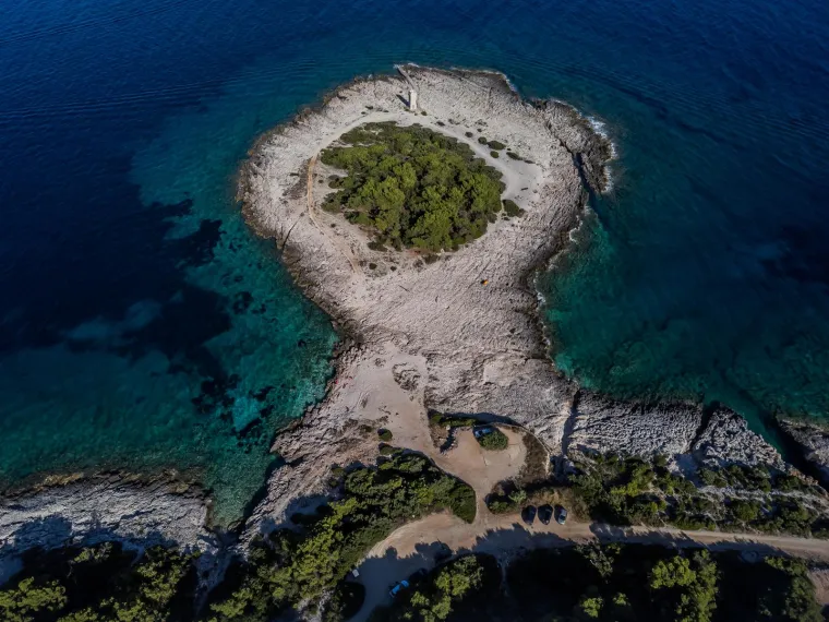 Rt Ražnjić najistočnija je točka Korčule i skriveni dragulj otoka. Na jugoistočnom dijelu otoka Korčule, kraj Lumbarde, krije se Rt Ražnjić. Lumbarda je drugo najstarije obalno mjesto na otoku, a priče kažu da je njen Rt Ražnjić prvo što su Grci ugledali po dolasku na otok.

Poluotok Ražnjić ujedno je i najistočniji dio otoka. Ima zanimljivu povijest - nekad su tu bile vojarne čiji derutni objekti godinama čekaju obnovu. Također, poznat je po svojoj predivnoj prirodi. Autohtona dalmatinska sorta alepskog bora dominira ovim područjem, stvarajući šumu koja privlači šetače i istraživače prirode.

Danas Ražnjić krasi samo osamljeni svjetionik. Da biste došli do ovog skrivenog raja, možete slijediti jednu od stazica koje vode uz obalu, počevši od popularne plaže Pržina.