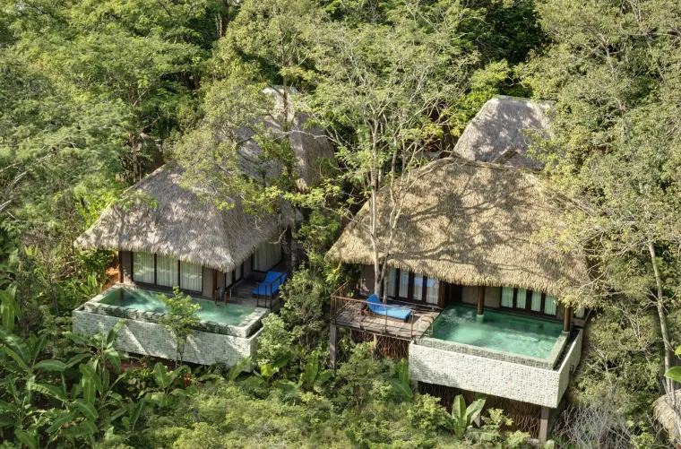 KEEMALA U PHUKETU, TAJLAND - Luksuzni resort čije su sobe raspršene po krajoliku poput luksuznih ptičjih gnijezda proglašen je jednim od najatraktivnijih novih hotela na svijetu. Keemala, smješten u Phuketu u Tajlandu, nudi tematske smještaje, a svaka vila ima vlastiti bazen i smještena je visoko iznad krošnji drveća, pružajući veličanstvene poglede. Tijekom noći, sobe osvjetljavaju brežuljak Kamala Baya na zapadnoj obali Phuketa, čime stvaraju magičnu atmosferu.
Keemala ima 38 vila s bazenima, podijeljenih u četiri različita stila – kućice od gline i slame, šatorske vile, kuće na drveću i vile u obliku ptičjih gnijezda. Svaki stil predstavlja jedan imaginarni klan ranih stanovnika Phuketa. Svaka vila ima privatni bazen i vanjsku terasu, dok je zajednički bazen srce resorta oko kojeg se sve odvija.  