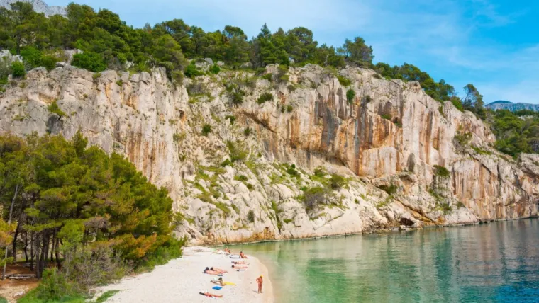 Nugal (Makarska): Okružena je borovom šumom, a do nje vodi šumska staza.