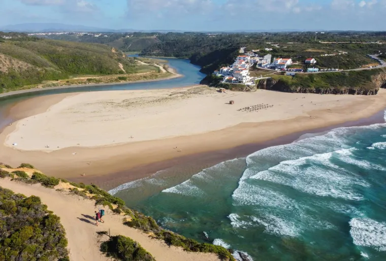 1. Praia de Odeceixe, Portugal: Okružena netaknutim prirodnim parkom Sudoeste Alentejano i Costa Vicentina, Praia de Odeceixe smještena je na ušću rijeke Seixe. Ova plaža je svijet za sebe u odnosu na pretrpane plaže juga Algarvea, nudi izvrsne uvjete za surfanje i bodyboarding, dok je plićaci rijeke čine pogodnom za malu djecu. Plaža je označena plavom zastavom, s prisutnim spasiocima ljeti, a nadomak je malo naselje sastavljeno uglavnom od nekoliko apartmana smještenih oko spletova ulica. Možete uživati u jelima poput choriza od crne svinje, portugalskih školjki ili svježih kamenica u baru Bar da Praia, a apartman možete rezervirati s fantastičnim pogledom na more.