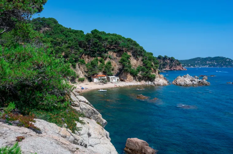 11. Cala Estreta, Costa Brava, Španjolska: Stjenovit i osebujan, veliki središnji greben dijeli Estretu na dva zasebna polumjeseca, okružena šumovitim liticama. Estreta je udaljena pola sata hoda kroz borovu šumu od parkirališta na plaži Castells i prekrasno je mjesto za plivanje, ali je stjenovita podloga pa nemojte ići bosi. Dobro će vam doći i suncobran te oprema za ronjenje. Tijekom vrhunca ljeta, tu je privremeni bar koji prodaje pića i grickalice, no za ručak prije ili poslije šetnje uputite se nazad na La Foscu, sljedeću plažu, gdje se nude svježi plodovi mora i pizza s hrskavom korom. 