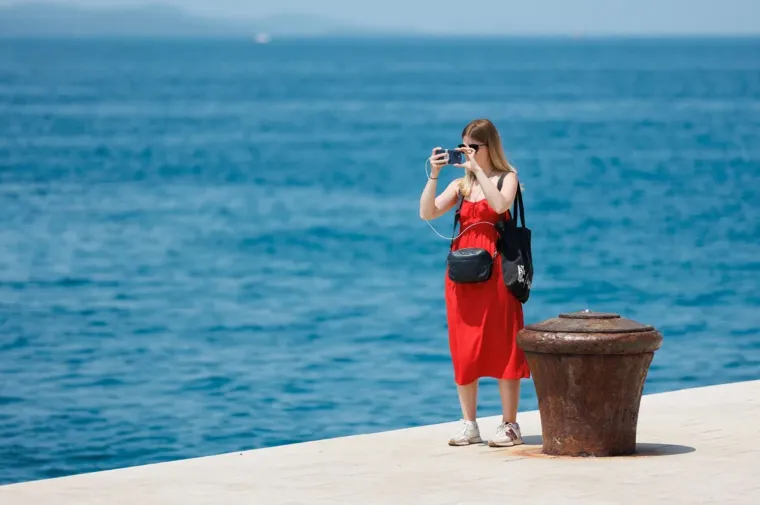 Djevojka u bijelom kao manekenka, a u prvi plan upao detalj na desnoj ruci