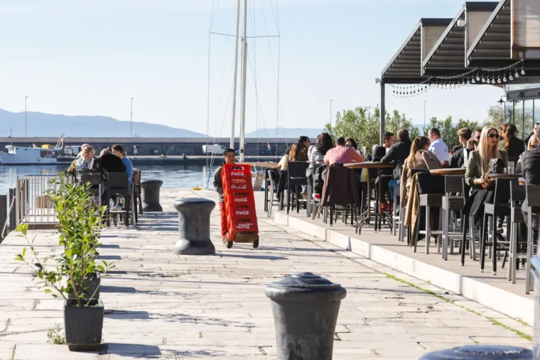 Dok zanosna plavu&scaron;a ispija kavu, djevojke u bikinijima hvataju prve zrake sunca