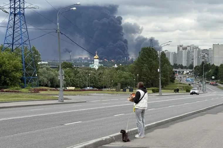 Rat? To nije njena briga! Polugola, sa slu&scaron;alicama na u&scaron;ima dok iza nje - Moskva gori
