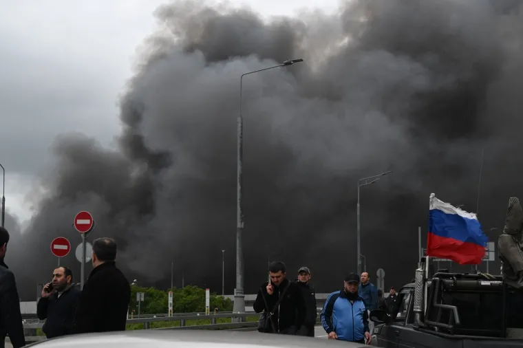 Rat? To nije njena briga! Polugola, sa slu&scaron;alicama na u&scaron;ima dok iza nje - Moskva gori