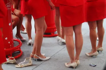 Mlade hostese turiste vuku za rukave u restorane na periferiji