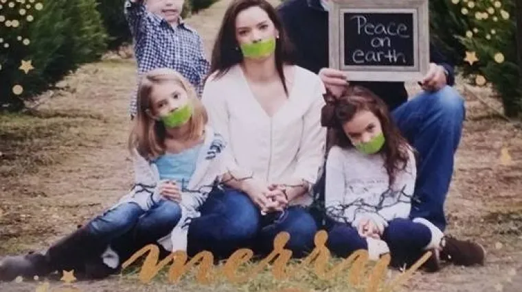 To je natpis koji tata drži iznad majke i kćerkica sa selotejpom na ustima