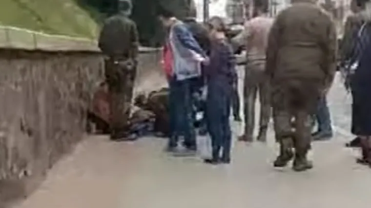 Dvoje je ljudi ozlijeđeno, jedna žena leži na tlu u blizini zgrade ukrajinske vlade