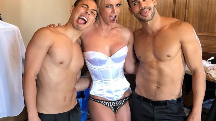 U bijelom korzetu i crnim gaćicama uživa u dru&scaron;tvu polugolih momaka