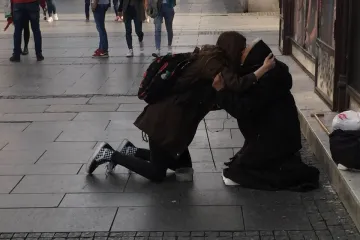 Djevojka se zaustavila kraj bake koja prosi, nešto su pričale, a onda se čvrsto zagrlile